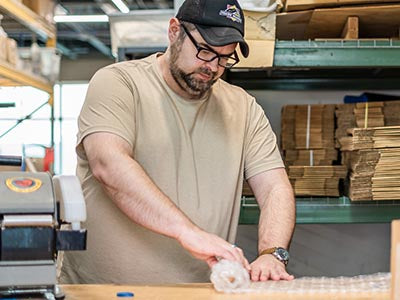 Gearheart Industry team member packing an order for shipping