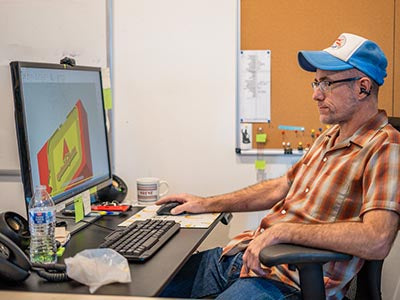 Gearheart Industry designer working on a customer's logo at a computer